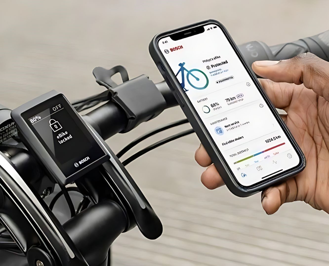 Afbeelding van een telefoon met de Bosch E-bike Flow app. Met een elektrische fiets met telefoonhouder op de achtergrond.
