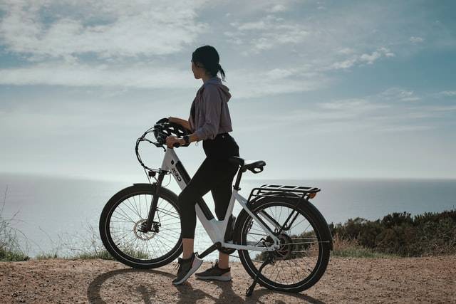 elektrische fiets met op de achtergrond de zon en de klif van een berg